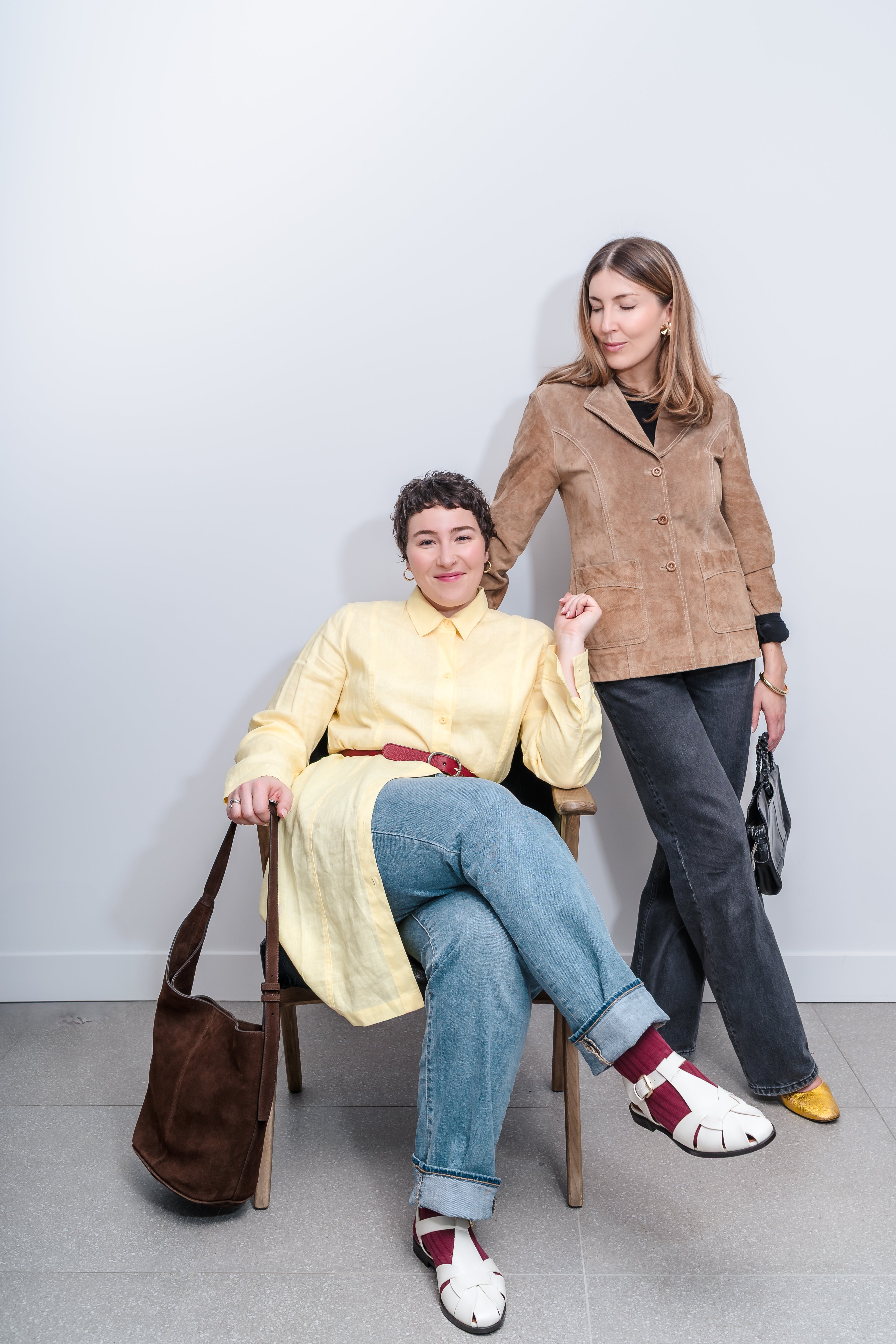 Two women posing together against a plain background
